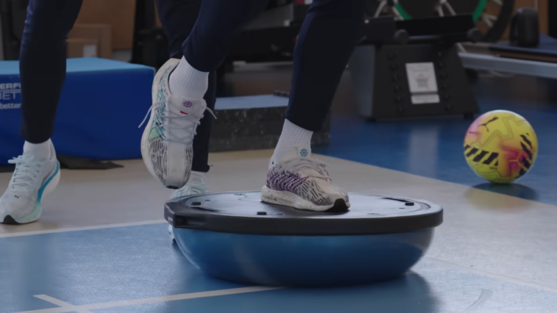 Fudbaler radi vežbe balansa i pokretljivosti na BOSU platformi tokom treninga